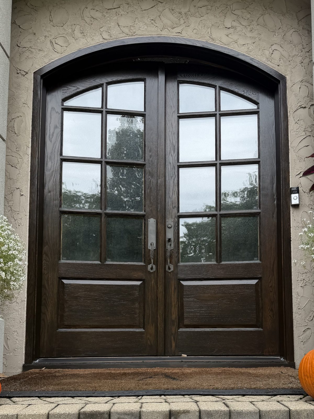 Arched oak double entry doors after refinishing in a deep espresso stain