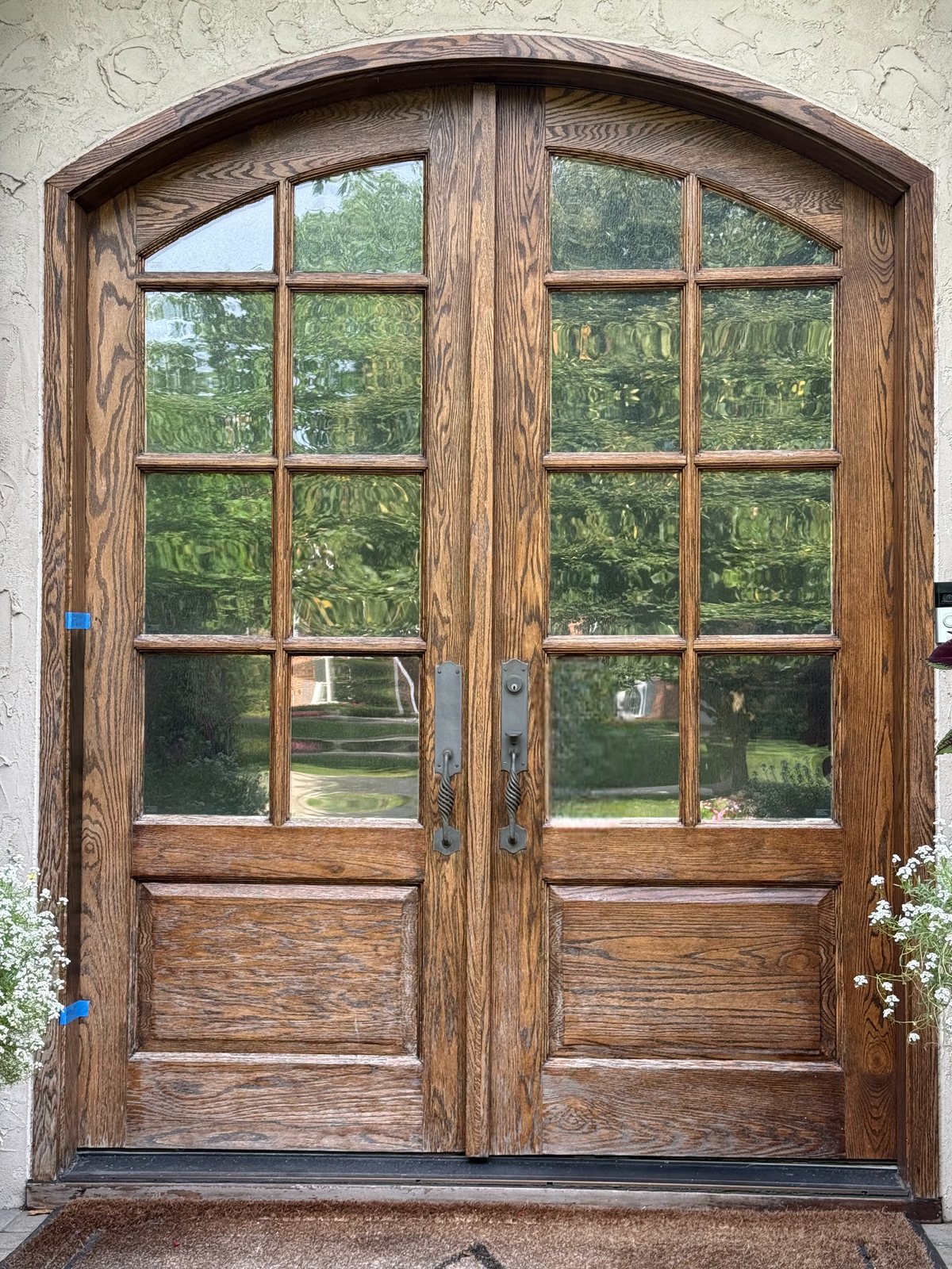 Arched oak double entry doors before refinishing, faded and weathered finish