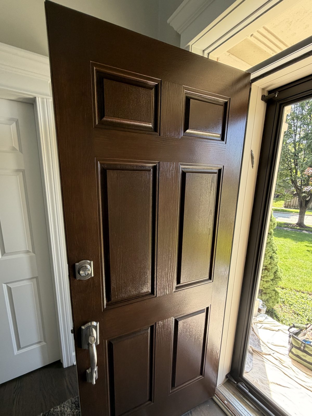 Six-panel entry door after refinishing in a dark walnut tone