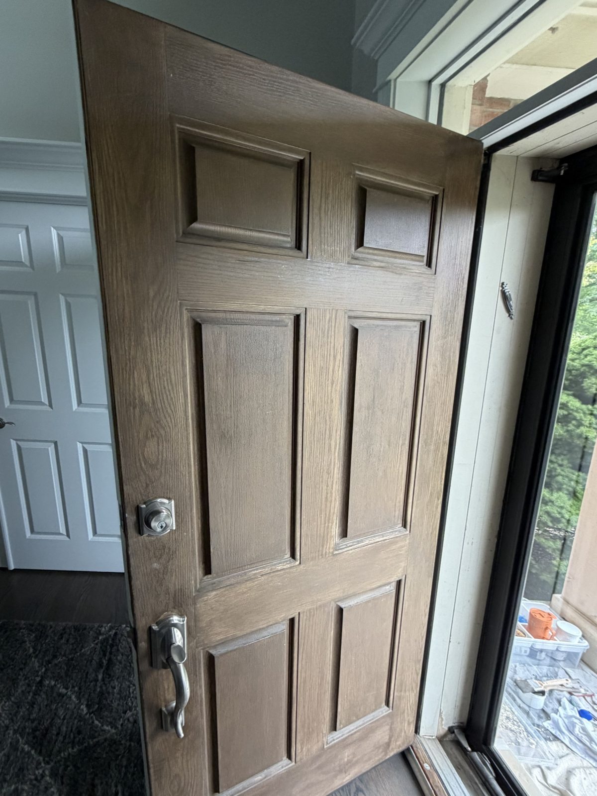 Six-panel entry door before refinishing, faded and worn finish